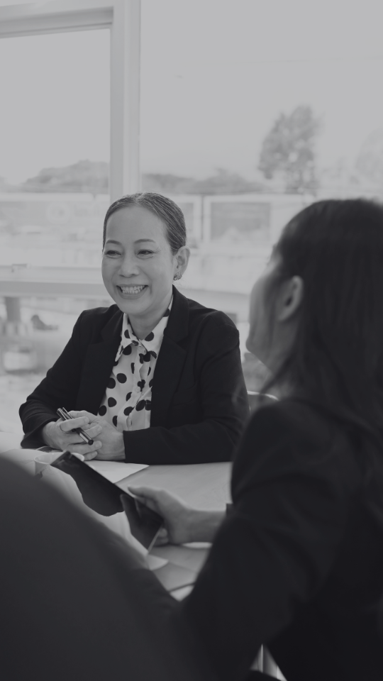 Smiling asian corporate woman sitting at meeting table Smiling asian corporate woman sitting at meeting table